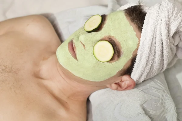 Man with clay facial mask in beauty spa — Stock Photo, Image