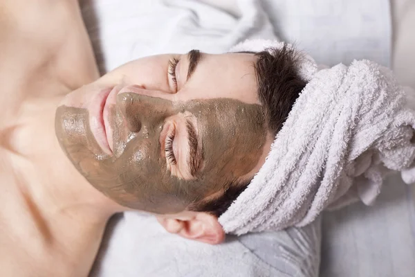 Man with a mud mask on this face — Stock Photo, Image