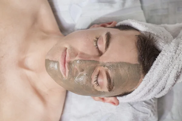Hombre relajante con una máscara de barro en esta cara —  Fotos de Stock