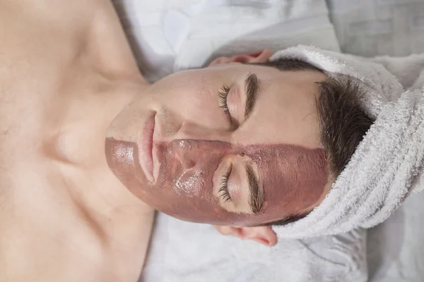 Man with a mud mask on this face — Stock Photo, Image