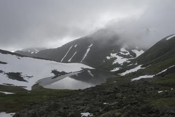 Lago de montanha com cumes nevados de montanhas — Fotografia de Stock