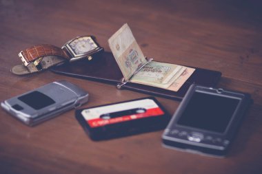 Beyefendinin cep telefonu, deri cüzdan, kol saati, cep bilgisayarı.