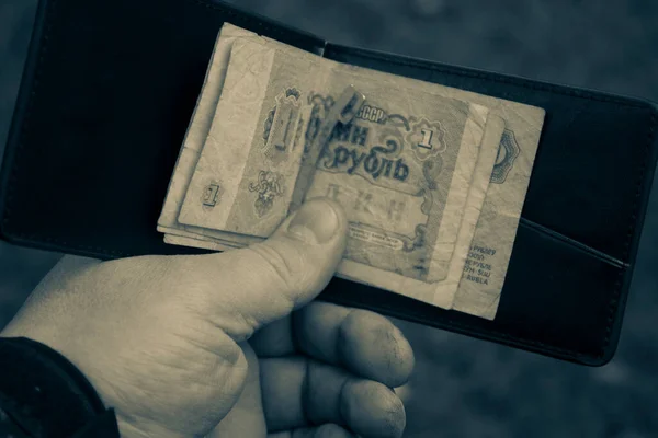男性の手の中にソ連の紙のレトロルーブルとブラウンレザーヴィンテージスタイリッシュな財布 ロイヤリティフリーのストック画像