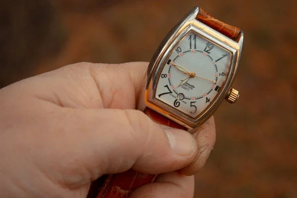 男性の手で茶色の革ストラップ上のスタイリッシュなヴィンテージ機械式腕時計 ストック画像