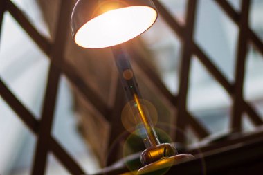 Masanın üzerinde eski Sovyet yapımı kahverengi bir lamba var.