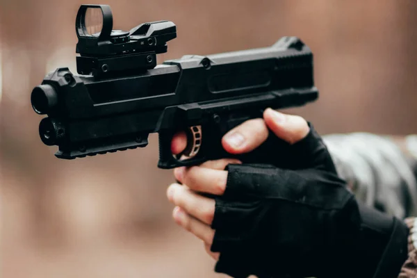Genç bir çocuğun elinde spor bir paintball silahı
