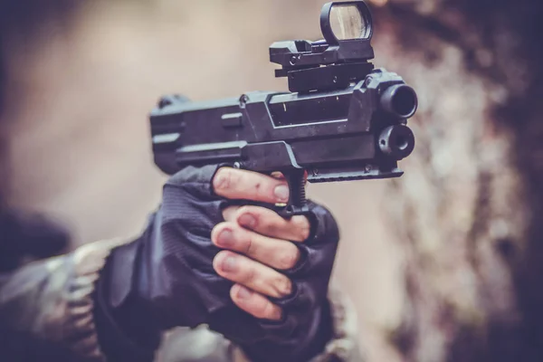 Genç bir çocuğun elinde spor bir paintball silahı
