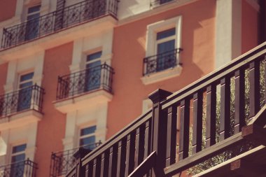 Pencereleri, balkonları ve gözlem güvertesi olan bir ev duvarı parçası.