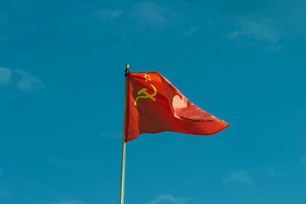 風になびくハンマーと鎌でソ連の赤い旗 ストック写真