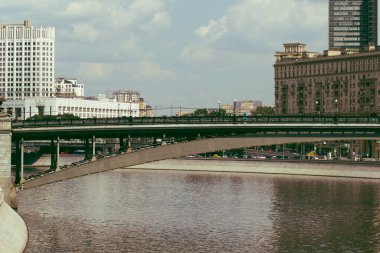 Güneşli bir günde büyük bir metropolde pitoresk bir nehir ve köprüler.