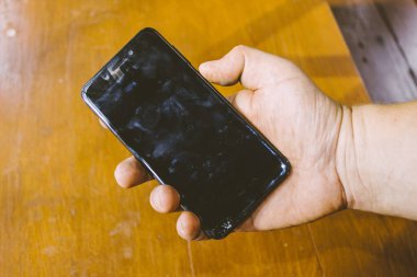 Elinde büyük bir ekran olan siyah bir cep telefonu.