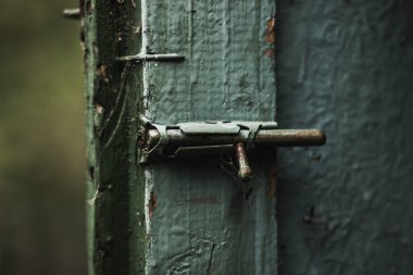 Eski Sovyet paslı demir retro mandalı boyalı ahşap bir kapının üzerinde.