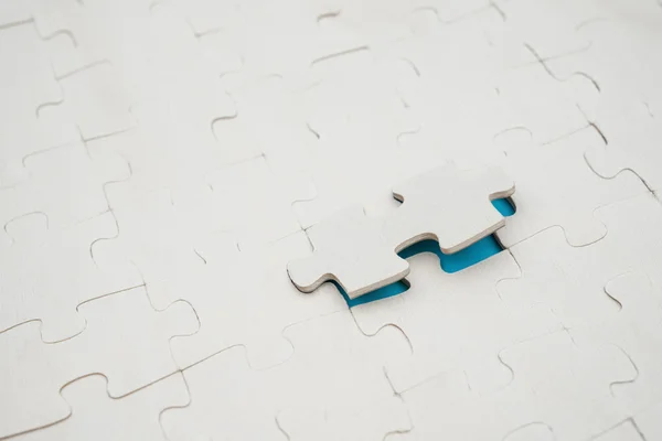 Jigsaw puzzle with one piece lifted up on blue background — Stock Photo, Image