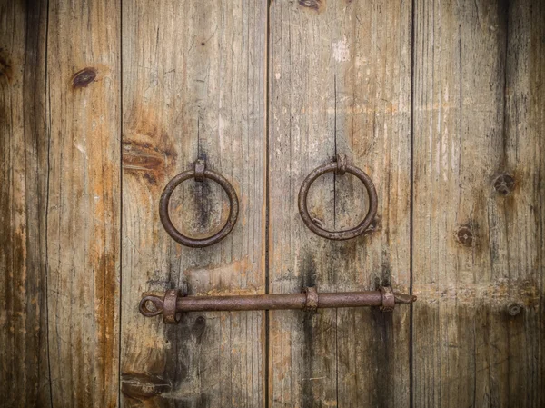 Ancient wooden gate with two door knocker rings and locks close-up — Stock Photo, Image