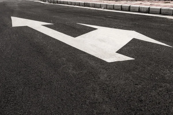 White directional arrows on blacktop — Stock Photo, Image