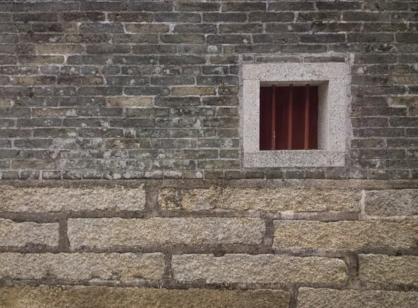 Una pequeña ventana en una pared de ladrillo — Foto de Stock