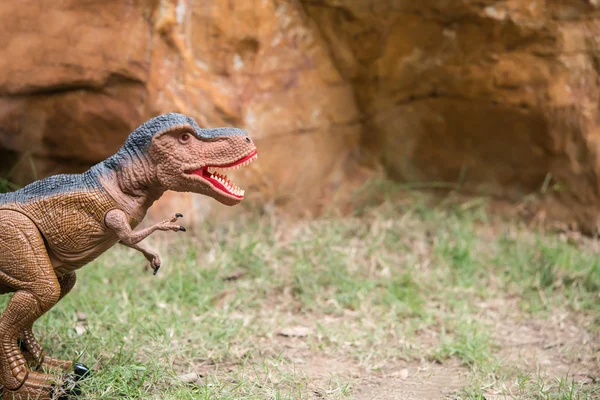 Tyrannosaurus speelgoed tegenover rock berg — Stockfoto