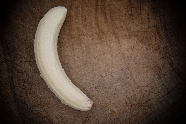 Unskin banana em uma prancha de madeira — Fotografia de Stock