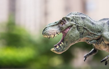 Tyrannosaurus oyuncak ağaçlar ve morden binası önünde
