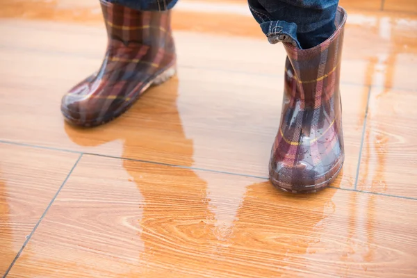 Bambino che indossa stivali di gomma impermeabili e in piedi sul pavimento bagnato — Foto Stock