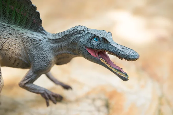Grijze spinosaurus speelgoed staande op rots close-up — Stockfoto