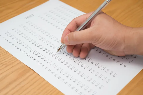 Filling test score sheet with ballpoint — Stock Photo, Image