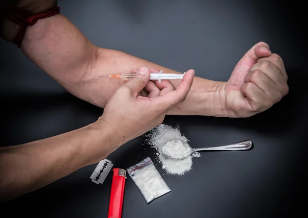 Young junkie doing drug injecting with spoon and lighter nearby — Stock Photo, Image