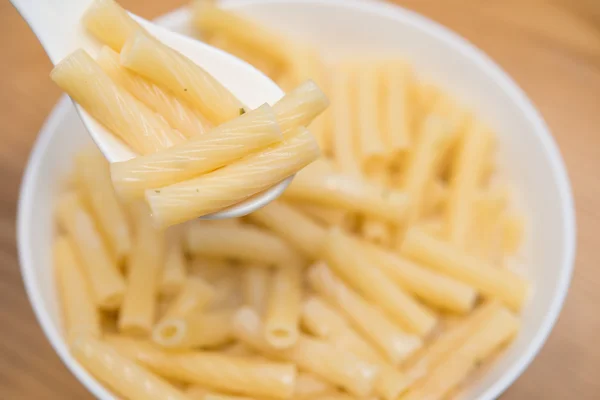 Colher tirando macarrão italiano fresco com molho de queijo de uma tigela — Fotografia de Stock