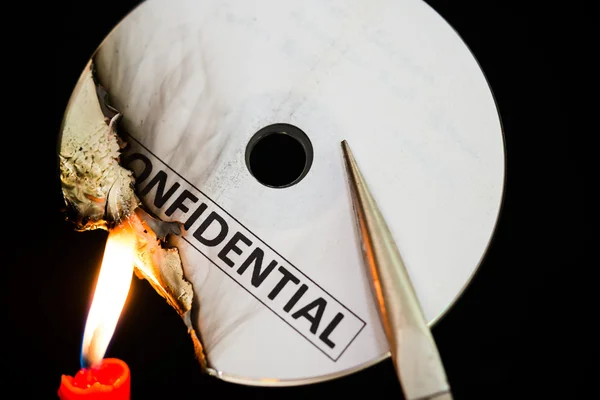 Burning a confidential compact disc with candle in dark SS — Stock Photo, Image