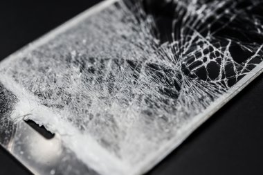 kırık ekran siyah bir zemin üzerine bir akıllı telefon