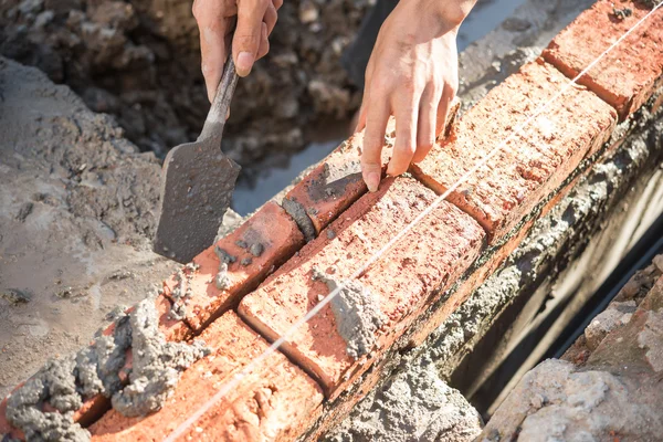 Yesero que forma una pared de ladrillo con cemento — Foto de Stock