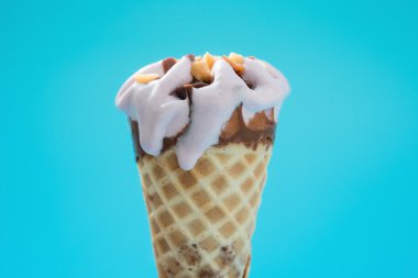 Fıstık lezzet dondurma koni üzerinde mavi bir backgrond erime
