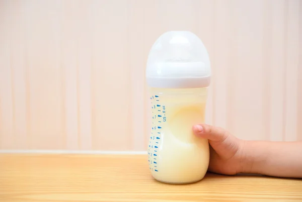 子供が哺乳瓶で粉ミルクを家庭で得ること — ストック写真