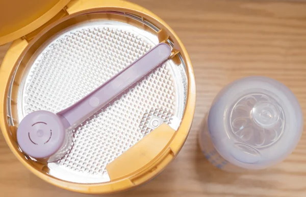 Blikje melkpoeder en Babyfles voor kinderen op de houten tafel — Stockfoto