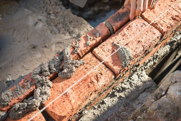 Yesero que forma una pared de ladrillo con cemento — Foto de Stock