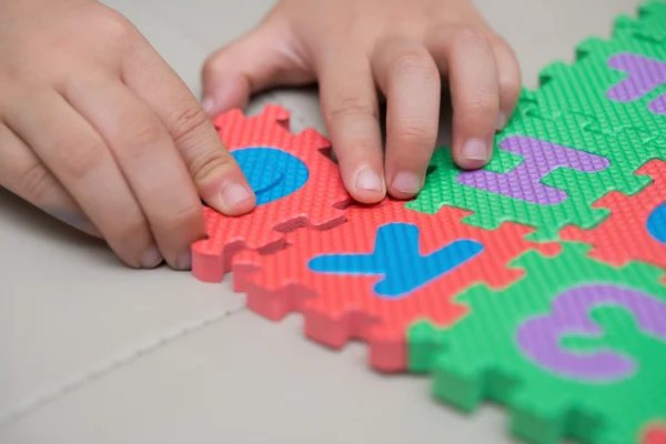 Criança jogando quebra-cabeças alfabeto — Fotografia de Stock