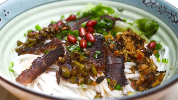 Añadir sopa a un tazón de fideos de arroz de guilin con rebanadas de carne asada — Vídeo de stock