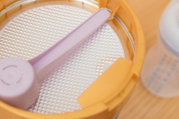 Boîte de lait en poudre et biberon pour enfants sur table en bois — Photo