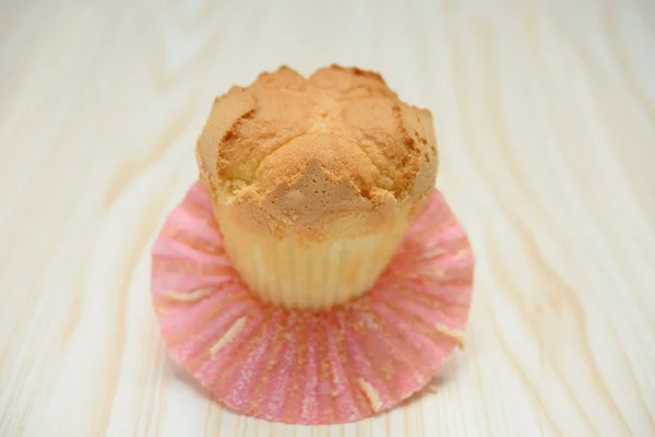 Homemade cup cake with the outer opened on a wood background — Stock Photo, Image