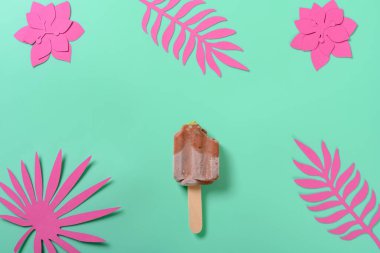 Yarısı yenmiş kırmızı fasulye ve yeşil çay aromalı buzlu şeker. Üzerinde yeşil arka planda çiçek ve yapraklar var.