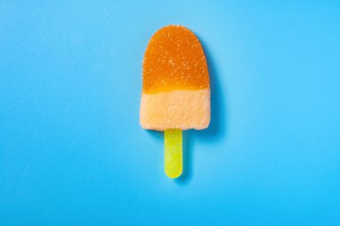Buzlu dondurma, portakal aromalı, mavi arka planda sakız.