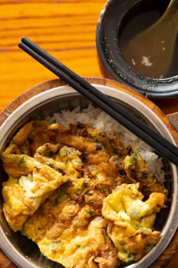 Üst manzara, çırpılmış yumurta, pirinç ve bir kase çorbayla hazır yemek.