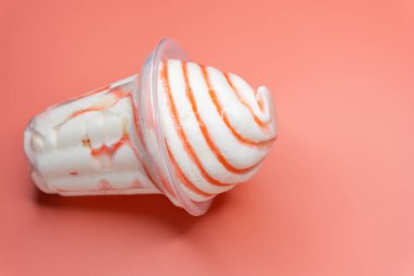 Pembe arka planda vanilyalı dondurma fincanı