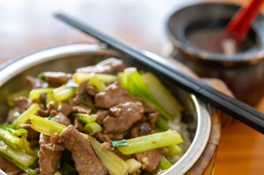 Kerevizli kızarmış domuz eti ve bir kase çorbanın yatay bileşimi.