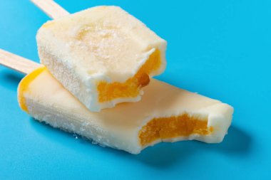 Mavi arka planda ısırık izleri olan doğranmış domuz dondurması.