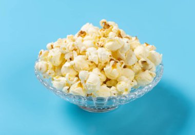 Mavi arka planda patlamış mısır kasesi