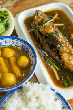 Köri aromalı balık köfteleri, sosisler, kızarmış balıklar, lahanalar ve pirinç dikey kompozisyonu olan fast food manzarası.;