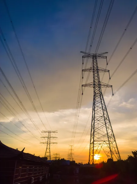 太阳落山时高电压电力塔 — 图库照片