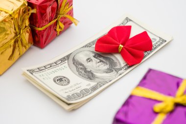 Kırmızı yay ve hediye kutuları ile dolar yığını