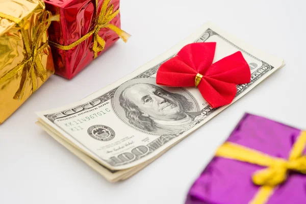 Kırmızı yay ve hediye kutuları ile dolar yığını